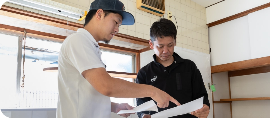 資料を見せながら話すスタッフ
